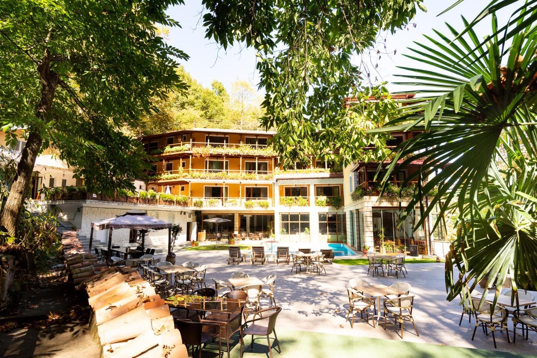 Une cour avec des espaces de détente en plein air, une piscine et un bâtiment doté de nombreux balcons.