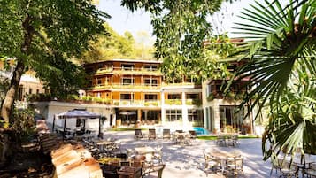 A courtyard with outdoor seating, a pool, and a building with multiple balconies.