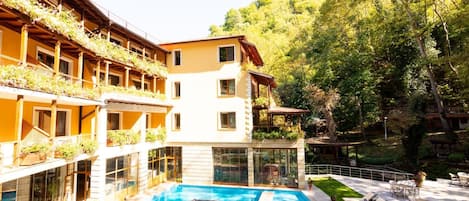 Un hotel con piscina, mobiliario exterior y jardín.