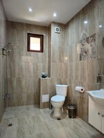 Un baño con inodoro, bidé y zona de ducha.