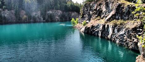 Un lago tranquilo rodeado de escarpados riscos y un bosque denso.