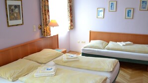 A hotel room with two beds, a nightstand, a lamp, and a window with curtains. - Gasthof Redl (Oed-Öhling)