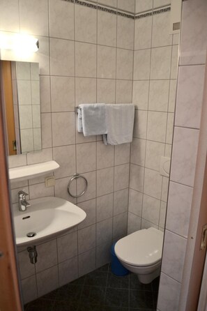 A bathroom with a sink, toilet, and a towel rack. - Gasthof Redl (Oed-Öhling)