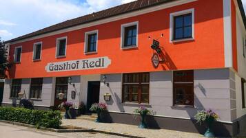 A building with a red facade and the name 'Gasthof Redl' on the front.