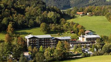 Ein Hotel mit mehreren Gebäuden, umgeben von üppiger Vegetation und Hügeln.
