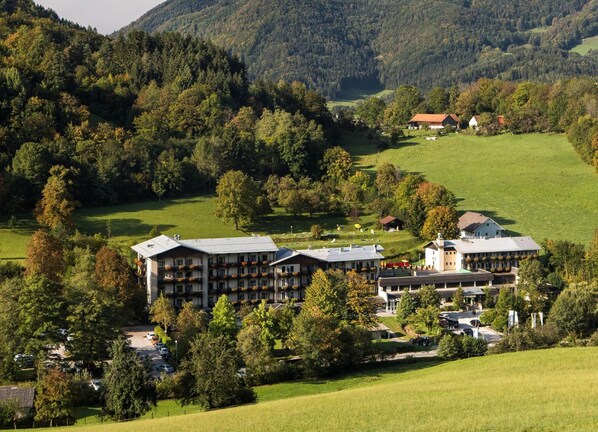 Un hotel con varias edificaciones, rodeado de exuberante vegetación y colinas.