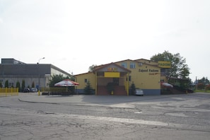 A building with a yellow facade, a sign reading 'BAR' above the entrance, and a Coca-Cola logo on the side.