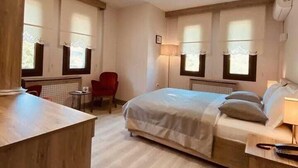 A hotel room with a bed, bedside table, lamp, and a small desk with a chair. - Hä±dä±rlä±k Konaklarä± (Safranbolu)