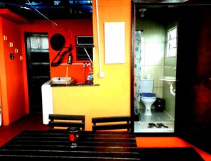 A small, compact room with a kitchenette, a toilet, and a bench. - Hostel Tavares Bastos (Rio de Janeiro)