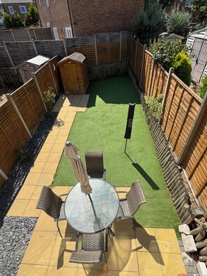 A backyard with a patio table and chairs, surrounded by a wooden fence and a small shed. - Modern 3Bedroom House, Garden, Free Parking, Sleeps 7, Easy Central London Reach (Orpington)