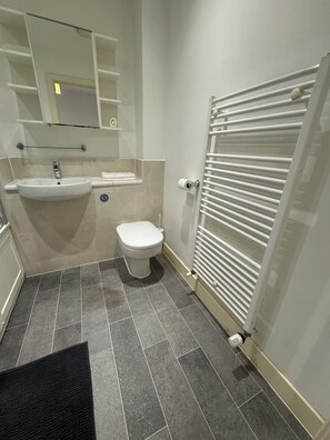 A bathroom with a white sink, a toilet, and a towel rack. - Modern 3Bedroom House, Garden, Free Parking, Sleeps 7, Easy Central London Reach (Orpington)
