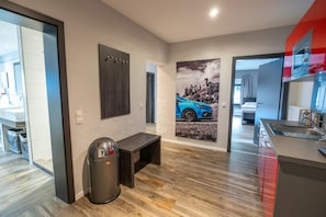 A modern kitchen with a built-in oven and a red accent wall. - Guesthouse Cockpit (Adenau)