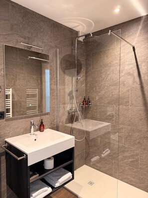 A modern bathroom with a glass-enclosed shower, a white sink, and a mirror above it. - Al Pozz Boutique Resort (Muralto)