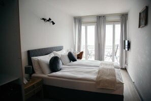 A bedroom with a bed, nightstand, lamp, and a view of the outside through the window. - Al Pozz Boutique Resort (Muralto)