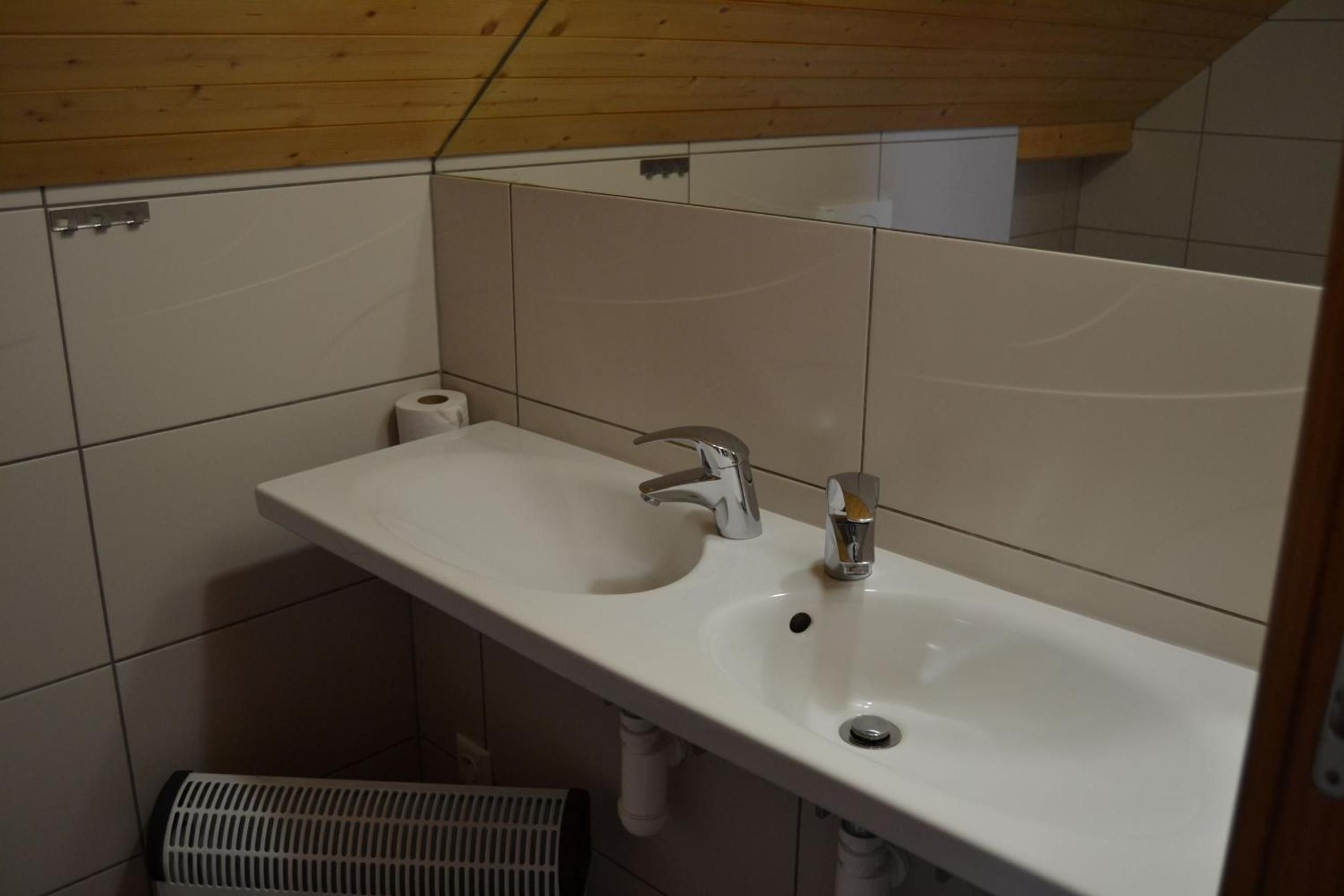 A bathroom with a white sink, a mirror, and a toilet.