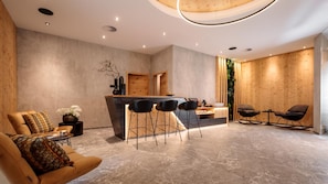 Un interior moderno con una zona de bar, asientos y una pared decorativa.