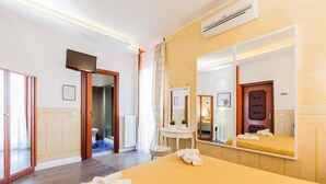 Una habitación de hotel con cama, baño, espejo y televisión.