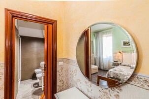 Un baño con inodoro, lavamanos y espejo.