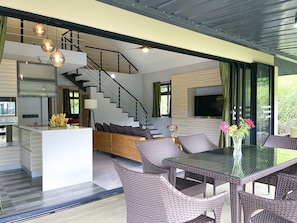 A modern interior with a central island, wicker furniture, a staircase, and a large window. - New cozy vacation home on Bora Bora (bora bora)