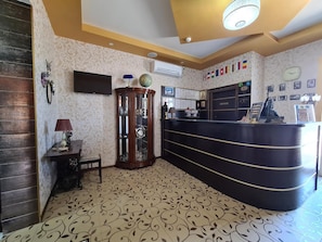A reception area with a curved black desk, a globe, and a wall-mounted clock.