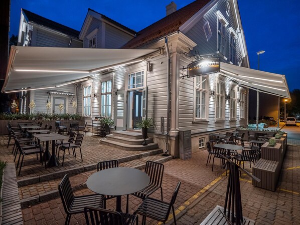 A building with outdoor seating and a covered patio area.
