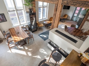 A modern interior with a dining area, a fireplace, and a large window.
