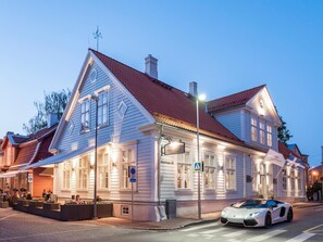 A traditional building with a red-tiled roof, large windows, and a sign indicating a restaurant.
