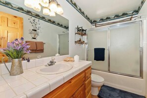 A bathroom with a white sink, wooden vanity, a mirror, a shower enclosure, and a toilet. - Teakwood Cozy Wood Cabin With Fireplace (Big Bear Lake)