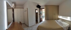 A hotel room with a bed, a desk, and a wardrobe. - Hotel Boschetto (Follonica)