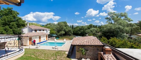Une propriété résidentielle dotée d’une piscine, d’un patio et offrant une vue sur une rivière.