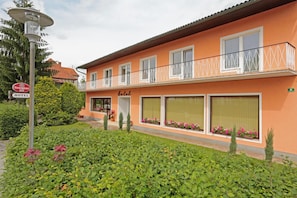 A hotel with a balcony, large windows, and a sign indicating a beer establishment nearby. - Hotel Reineldis (Mureck)