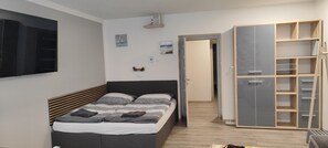 A bedroom with a bed, a wardrobe, and a television on the wall. - Minihotel Vitex (Prague)