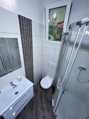 A modern bathroom with a glass shower enclosure, a white sink with a mirror, and a toilet. - Minihotel Vitex (Prague)