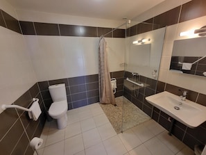 Un baño con inodoro, ducha y lavamanos.