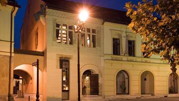 Ein historisches Gebäude mit Bogenfenstern und einer Straßenlaterne davor.