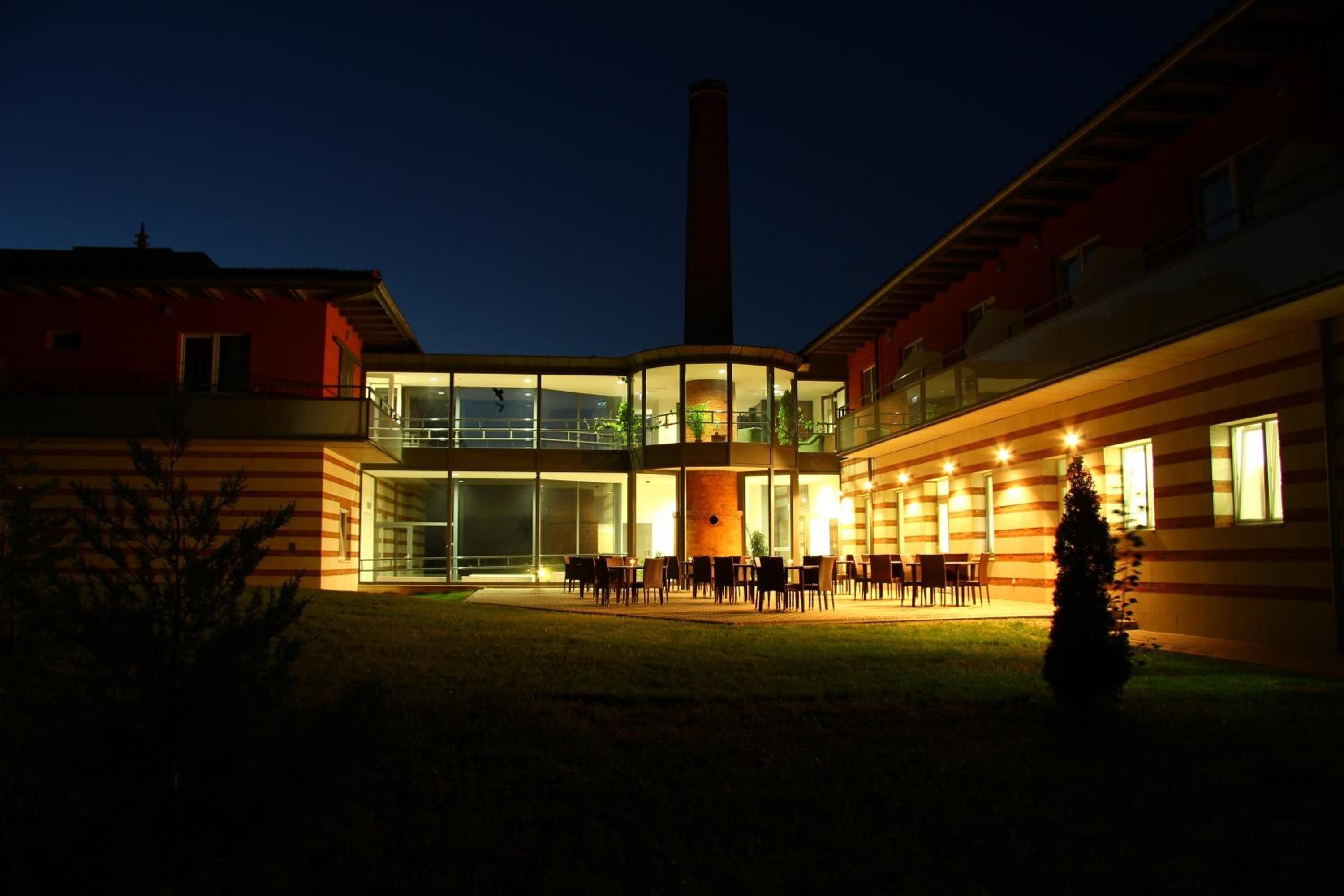 A building with a central courtyard, large windows, and a chimney.