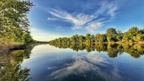 A calm river reflecting trees and sky. - Hotel Kelep (Tokaj)
