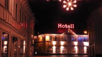 Un hotel con un letrero visible que dice 'Hotel', luces colgantes y una decoración con forma de copo de nieve.