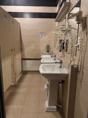 A restroom with three sinks, a hand dryer, and a paper towel dispenser. - Loft Car Factory (Warsaw)