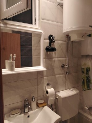 A bathroom with a toilet, sink, and shower. - Hostel Oasis (Belgrade)