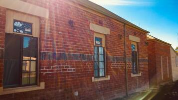 A brick building with three windows, each with a small awning.