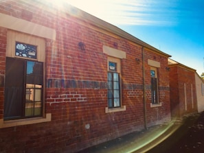 A brick building with three windows, each with a small awning.