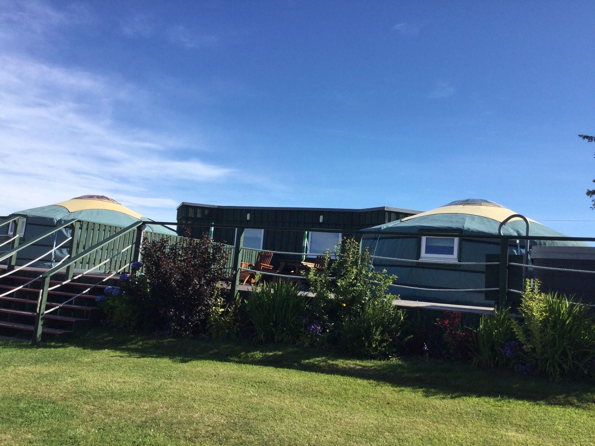 Yurts with external stairs and a small garden area.