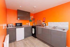 A compact kitchen with grey cabinets, a white refrigerator, a microwave, and a sink. - Orange Yurt With Hot Tub- Sleeps 3, Parking & Pe (Turriff)
