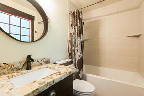 Un baño con lavamanos, inodoro y ducha.