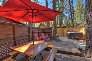 A wooden deck with picnic tables and a red umbrella, surrounded by wooden fences and trees. - Summit Happy Mountain Cabin (Big Bear Lake)