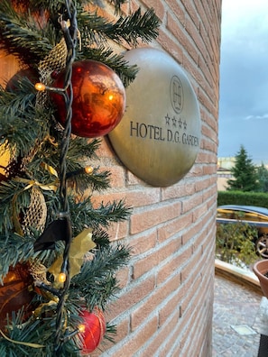 Una pared de ladrillo con una placa que dice 'HOTEL D.G. GARDEN'.