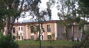 Un edificio con fachada de ladrillo, múltiples ventanas y cielo despejado.