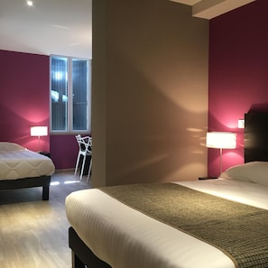 A hotel room with two beds, a window, a chair, and a lamp. - Le Brin D Olivier (Bourg-Saint-Andeol)