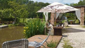 An outdoor seating area with a table, chairs, and a large umbrella.